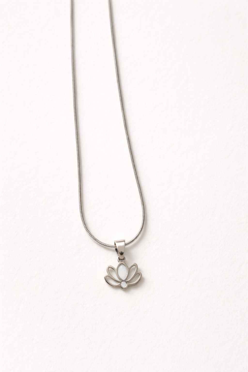 שרשרת מסטיינלס-סטיל בצבע כסף , תליון קטן בצורת לוטוס שילוב של חלול ומילוי בצבע לבן.